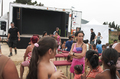 Público infantil y familiar viendo un espectáculo de la compañía italiana Caravan en un escenario móvil al aire libre.