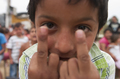 Primer plano de un niño mirando a cámara durante una actividad comunitaria del proyecto Caravan.