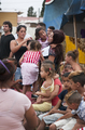 Integrantes de la compañía italiana Caravan y participantes posan al aire libre después de una representación teatral en el barrio del Vacie..