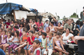 Público infantil sentado frente al escenario móvil durante una representación del proyecto Caravan.