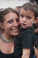Retrato de una mujer sonriente con un niño pequeño durante una jornada comunitaria de Caravan.