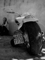 Motocicleta aparcada fotografiada desde atrás en blanco y negro.