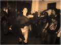 Escena nocturna con varias personas en un encuentro motero de ambiente oscuro.