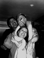 Tres personas abrazadas y sonrientes en una escena nocturna de ambiente motero.