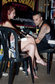 Mujer sentada en un bar durante una escena nocturna de la serie Motos y tatuajes.