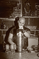 Retrato en sepia de un hombre sentado con chaleco motero y fondo de bar.