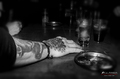 Persona tumbada sobre una mesa de bar en una escena nocturna y oscura.