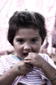 Niña mirando a cámara mientras come en una escena cotidiana de El Vacie.