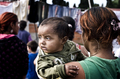 Niño entre adultos durante una escena cotidiana y familiar en el asentamiento de El Vacie.