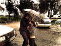Mujer abraza a un niño en una escena afectiva del asentamiento.