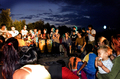 Grupo de personas reunidas al anochecer en una escena comunitaria de El Vacie.