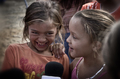 Dos niñas sonríen juntas en un retrato cercano de la serie Asina.