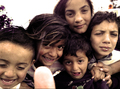 Grupo de niños abrazados y sonriendo en una fotografía documental de El Vacie.