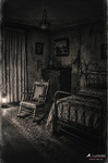Habitación antigua vacía con cama, silla y luz tenue, dentro de la serie Las puertas cerradas.