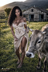 África camina junto a la vaca en un prado cercano a las casas de piedra de Treceño.