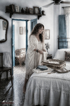 Alina coloca la ropa dentro de una maleta abierta sobre la cama de la habitación.