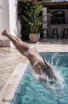 Alina entra de cabeza en la piscina mientras el agua salpica alrededor de su cuerpo.