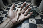 Gran mano humana abierta sosteniendo o acercándose a una pequeña figura, en una escena de contraste entre escalas.