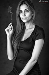 Carmen sentada con un vestido oscuro y un cigarrillo entre los dedos.