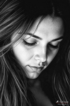 Primer plano en blanco y negro de Carmen con los ojos cerrados y el rostro inclinado, enmarcado por su cabello largo.